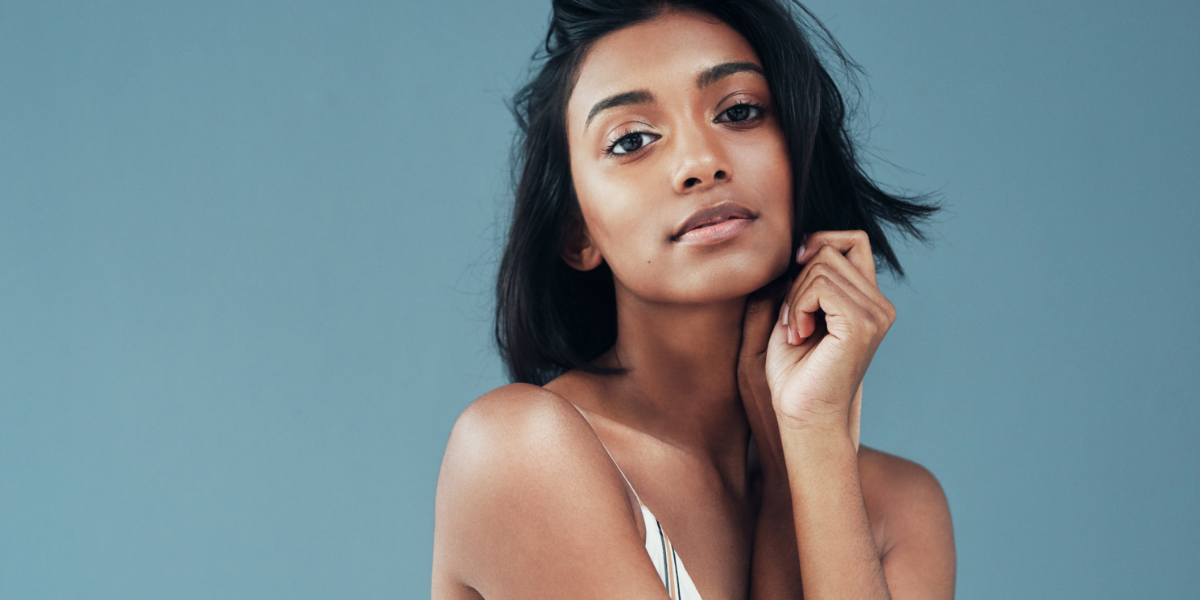 DLV-September2023Blog-SkinCancerDarkSkin-Header Woman with dark skin on blue background