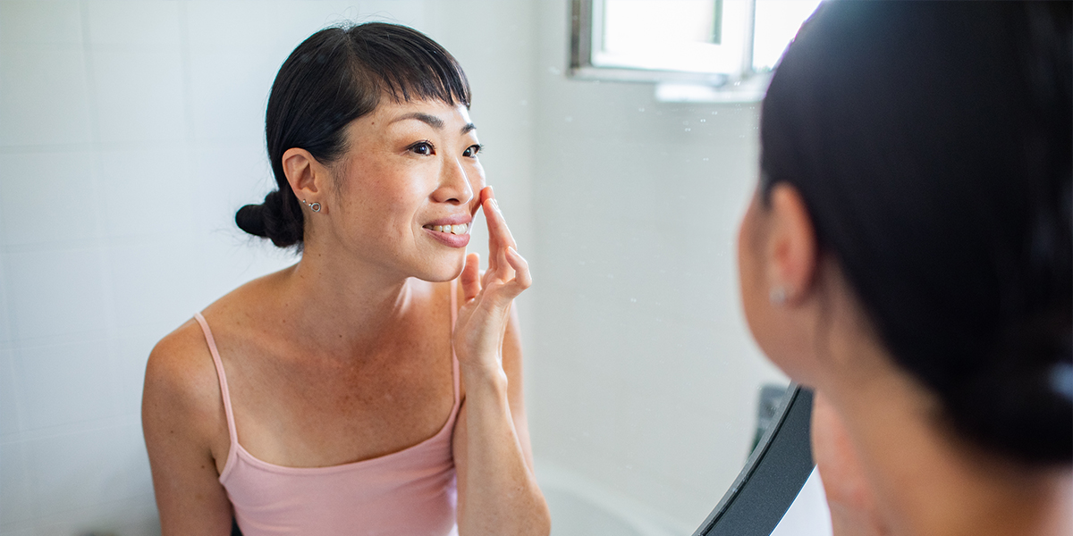 Blog-SummerSkinCheck,WhatSkinCancerReallyLooksLike,HeaderImage Woman looking at herself in mirror up close