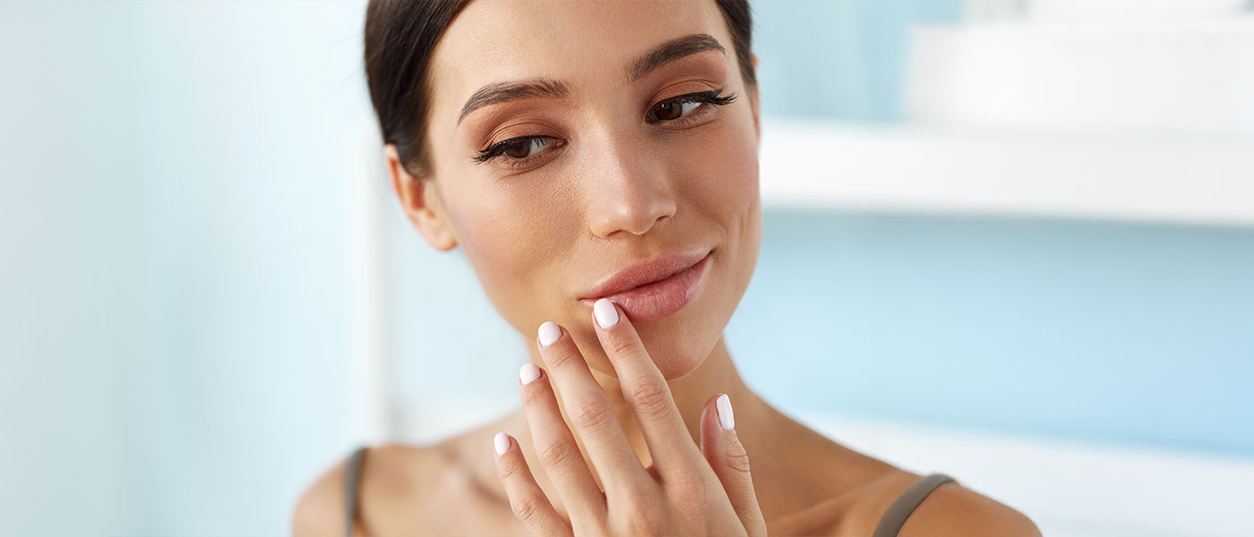 Woman on light blue background touching lips
